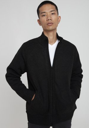 Sort zip-up cardigan lavet af struktureret strikket materiale med ribbet krave og manchetter. Indeholder sidelommer og har et lige pasform design.