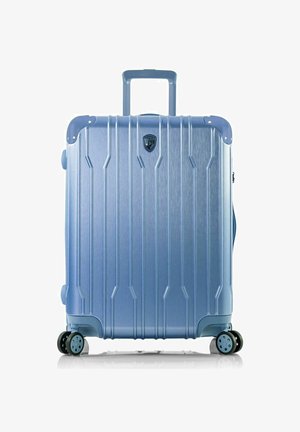 Hard-shell suitcase in metallic blue with diagonal ridges, a telescopic handle, and four spinner wheels for smooth mobility.
