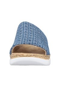 Sandal en denim bleu avec une tige texturée, un design à bout ouvert et une semelle intermédiaire en liège naturel sur une semelle en caoutchouc blanche.