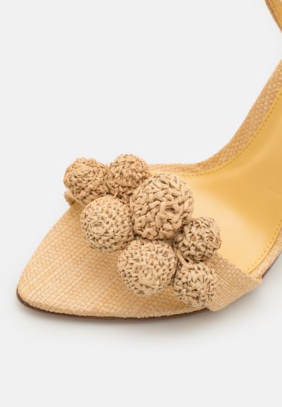 Yellow woven fabric high-heel shoe with textured square toe and large decorative woven spheres in varying sizes at the front.