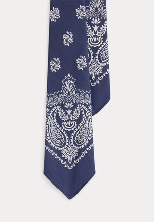 Material albastru închis cu imprimeu alb complicat în stil bandană, cu modele paisley și florale, pe vârful înclinat.