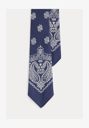 Tengerészkék szövet fehér, bonyolult paisley és virágmintás bandana-stílusú nyomtatással, szögben elvágott véggel.