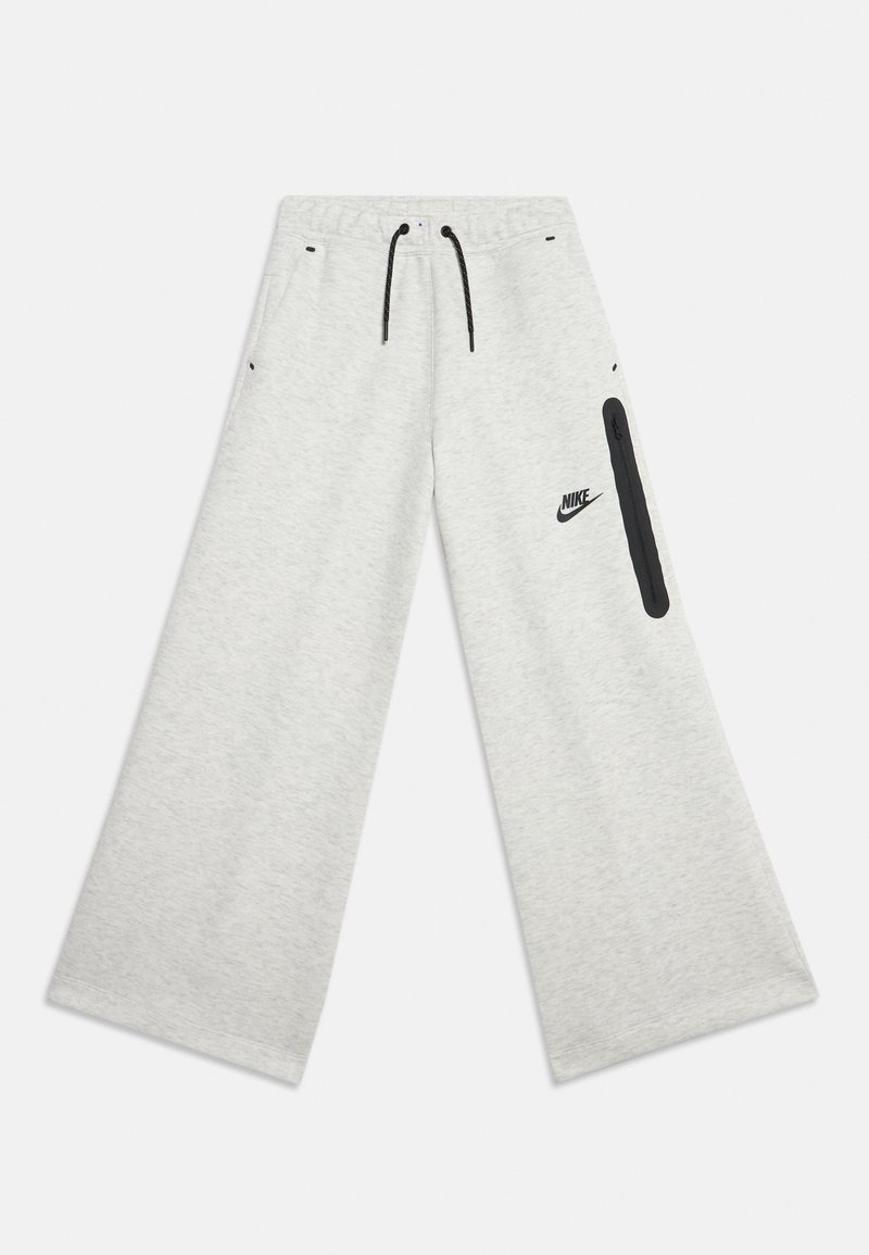 Ανοιχτό γκρι φαρδιά φόρμα Nike με ελαστική μέση, μαύρο κορδόνι, μπροστινές τσέπες και κάθετη μαύρη τσέπη με φερμουάρ στο δεξί πόδι.