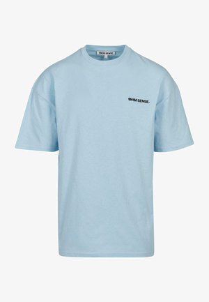 Világoskék, rövid ujjú pamut póló, kerek nyakkivágással és egy kicsi fekete logóval a mellkason. Egyszerű, laza fazon.