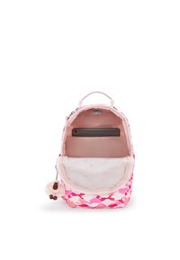 Růžový batoh s geometrickým vzorem, který má hladký textilní povrch a chlupatou klíčenku ve tvaru opičky. Uvnitř je polstrovaná kapsa na tablet.