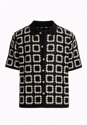 Cárdigan de manga corta en blanco y negro con botones, patrón geométrico de cuadros y cuello negro sólido.