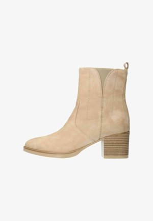 Beige suède enkellaars met hoge gestapelde hak, gestikte details, elastische zijkanten en een achterste lus voor gemakkelijk aan- en uittrekken.