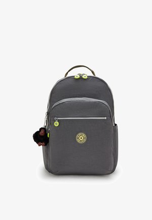 Zaino grigio con tessuto testurizzato, dotato di doppie cerniere con tiranti verdi, patch del logo e un accessorio portachiavi a forma di scimmia nera.