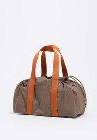 Bolsa de deporte de nylon marrón con asas de web naranja, que cuenta con un cierre de cordón y una textura sutil, diseño compacto y redondeado.