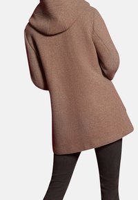 Cappotto marrone con cappuccio, realizzato in un tessuto texturizzato, di lunghezza media e dal taglio rilassato, abbinato a pantaloni neri slim-fit.