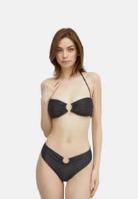 Costume da bagno nero composto da un top bandeau con un accento circolare centrale e da un paio di slip a vita alta coordinati, entrambi con texture arricciata.