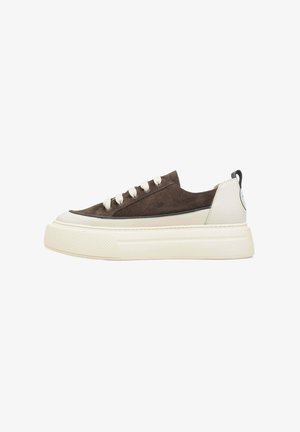 Bruine suède sneakers met een witte rubberen zool, crème accenten, vetersluiting en een onderscheidend textuurpatroon op de zool.
