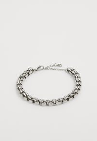 Bracelet en métal argenté avec des maillons ovales et ronds entrelacés, doté d'un fermoir mousqueton et d'une chaîne ajustable à une extrémité.
