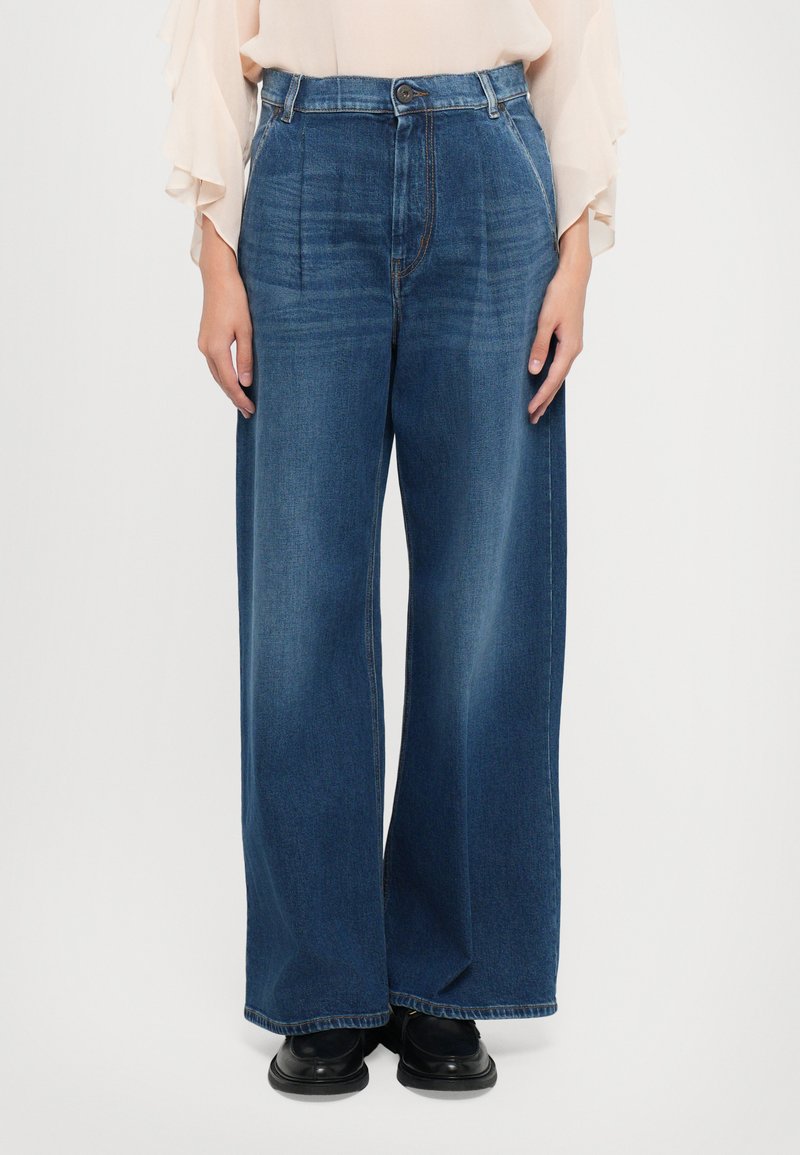 Weite Denim-Hosen in Dunkelblau mit hoher Taille, Vorderfalten und Nähdetails. Glatte Textur mit lässigem Schnitt.