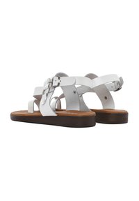 Sandalias de piel blanca con hebillas ajustables, que cuentan con una suela plana marrón y múltiples diseños de correas para un ajuste seguro.