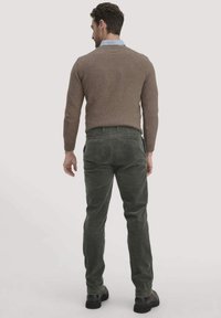 Bruine wollen trui en donkergroene corduroybroek, van gestructureerde stof en standaard pasvorm. Zwarte schoenen maken de outfit compleet.