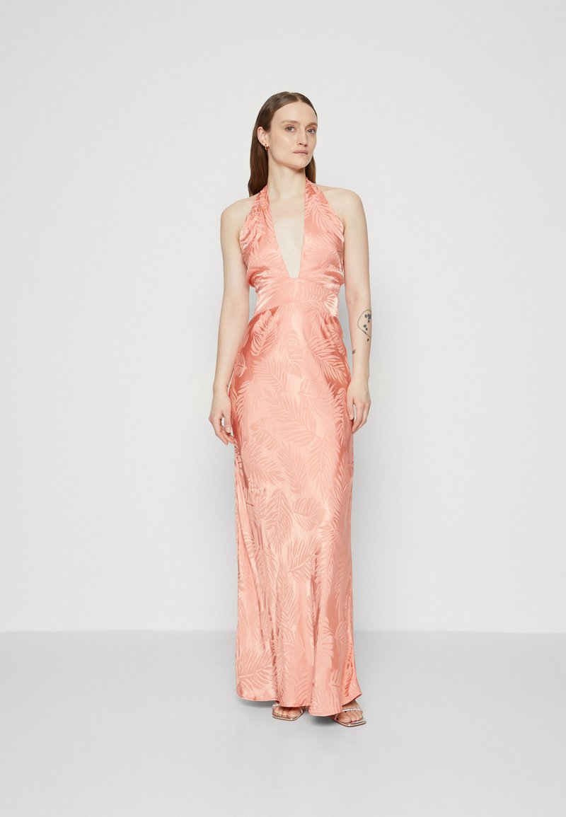 Robe halter en satin rose avec un décolleté en V profond, taille cintrée, et motif de feuilles de palmier. Longueur jusqu'au sol avec une forme fluide et un minimum de détails.