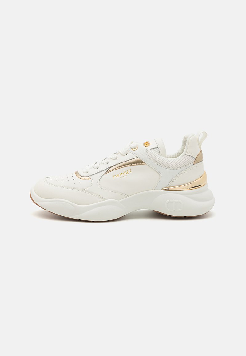 Witte sportieve sneakers met gouden accenten, ronde neus, textuurdetails en een lage profielzool. Veters en een achterste lussen voor eenvoudig aan- en uittrekken.