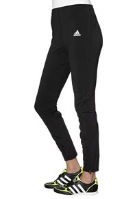 Czarne spodnie sportowe z lekkiego materiału, z białym logo Adidas, kieszeniami na zamek i dopasowanym krojem zwężającym się przy kostkach z suwakami.