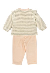 Top à manches longues rayé en crème et beige avec des accents en volants, associé à un pantalon rose pâle. Le matériau semble en polaire et confortable.