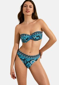 Ensemble de bikini comprenant un haut sans bretelles et un bas taille haute en bleu foncé avec des motifs floraux en bleu et turquoise. Texture de tissu douce.
