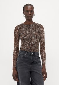 Long-sleeve, fitted top in a brown leopard print pattern, made from a stretch fabric, paired with high-waisted, black denim jeans.