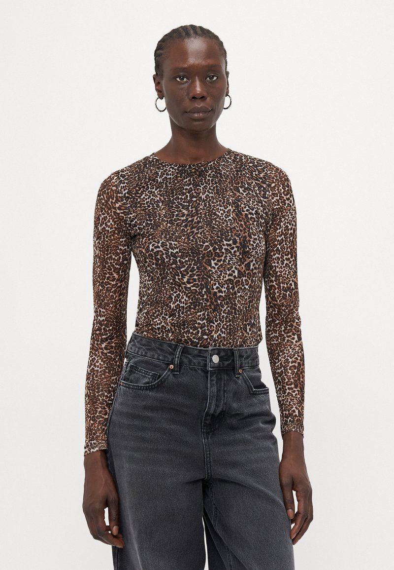 Long-sleeve, fitted top in a brown leopard print pattern, made from a stretch fabric, paired with high-waisted, black denim jeans.