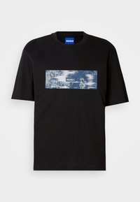Sort T-shirt med korte ærmer med et blåt og hvidt rektangulært grafisk tryk og "HUGO" tekst på brystet, samt et blåt mærke indeni kraven.