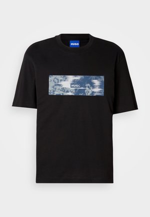 Μαύρο κοντομάνικο T-shirt με μπλε και λευκό ορθογώνιο γραφικό και κείμενο "HUGO" στο στήθος, και μπλε ετικέτα μέσα στον γιακά.