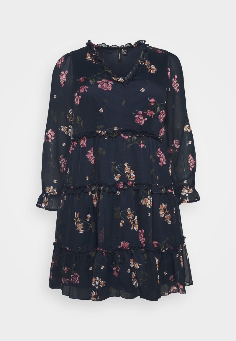 Robe florale bleu marine en tissu léger, avec des manches longues, un col et des manches à volants, et une jupe à volants ornée de motifs de fleurs roses et blanches.