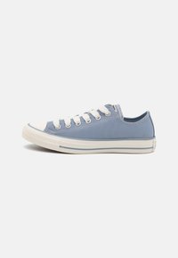 Világoskék vászon sneaker fehér gumitalppal, orr-résszel és fűzőkkel. Fűzött részletekkel és csíkos díszítéssel rendelkezik a talpon.