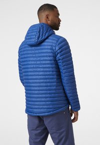 Chaqueta de plumón azul con capucha, con secciones de acolchado horizontal. Hecha de material ligero, mostrada desde un ángulo trasero.