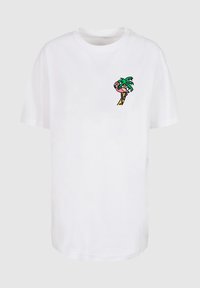 Camiseta de algodón blanca con un colorido diseño bordado de una palmera y un flamenco en la parte izquierda del pecho. Corte clásico, mangas cortas.