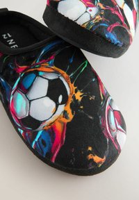 Pantofole nere con un design colorato caratterizzato da schizzi di vernice e grafiche di palloni da calcio. Superficie morbida e testurizzata con una forma arrotondata.