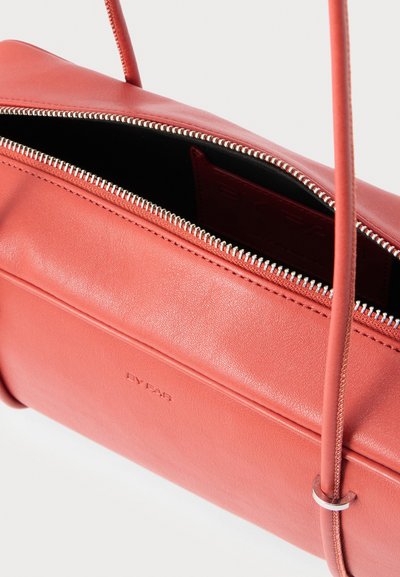 Kožena ružová taška na rameno s strieborným zipsom, tenkými remienkami a vyrazeným značkovým názvom "BY FAR" na prednej strane.