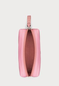 Estuche rosa con cremallera hecho de un material suave; cuenta con un forro interior marrón y un tirador de cremallera a juego con detalles del logo.