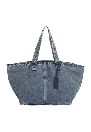 Large blue denim tote bag with double shoulder straps and a hanging navy tag against a white background.
