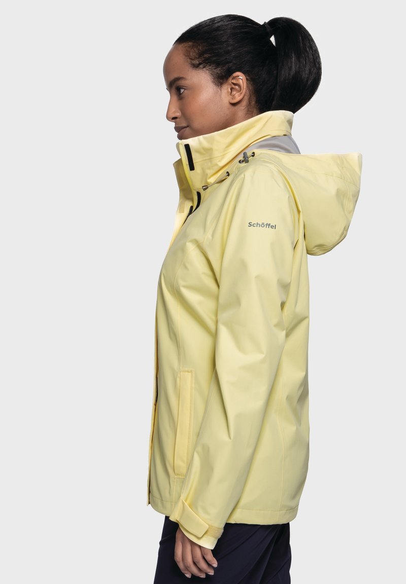 Geel waterproof jack heeft een capuchon, verstelbare trekkoorden en zijzakken. Gemaakt van een glad, lichtgewicht materiaal met een getailleerd ontwerp.