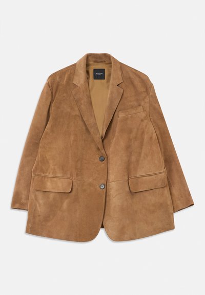 Blazer da uomo in suede marrone con due bottoni, rever a intaglio, due tasche a patta e una tasca sul petto, posato su uno sfondo bianco.