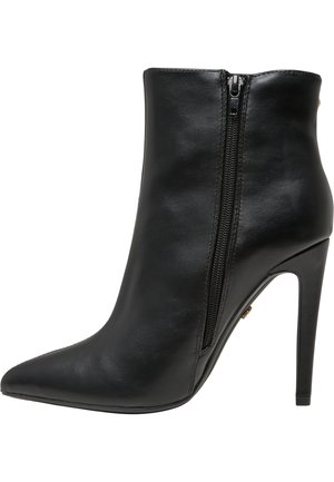 Stivale alla caviglia in pelle nera con punta appuntita, dettaglio con zip laterale e tacco alto a stiletto. Texture liscia e design elegante.