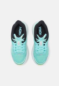 Bottines de course bleu clair avec une tige en maille respirante, accents noirs et semelle blanche. Présente des lacets et un logo sur la languette.