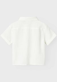 Biała koszula z krótkim rękawem z kołnierzykiem, wykonana z miękkiego, teksturowanego materiału. Posiada podwinięte mankiety i czysty, minimalistyczny design.