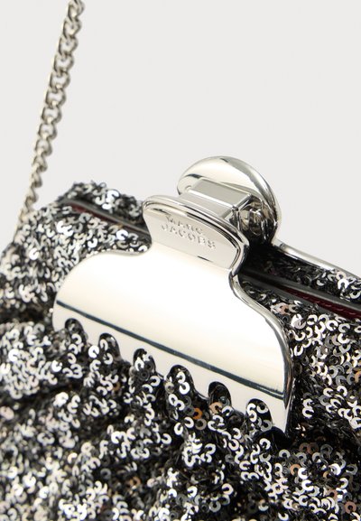 Fekete flitteres borítéktáska ezüst színű fém zárral. Texturált felülettel és láncos pánttal, kiemelve a részletgazdag kidolgozást.