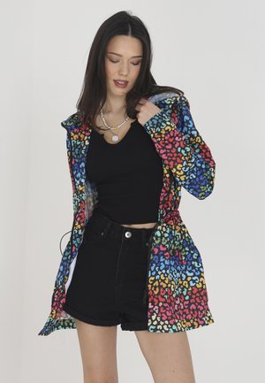 Kleurjack van lichtgewicht materiaal met een gekleurd dierenprint. Voorzien van een capuchon en trekkoord in de taille. Gepaard met een zwarte top en shorts.