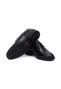 Chaussures habillées en cuir noir au fini lisse, à bout arrondi et à lacets. Semelle en caoutchouc texturé avec un motif de semelle.