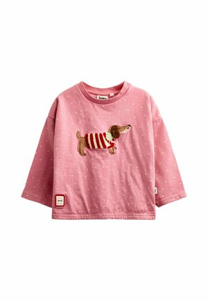 Lyserød langærmet småbørns t-shirt med hvide polkaprikker og en broderet gravhund iført en rød og hvidstribet sweater foran.