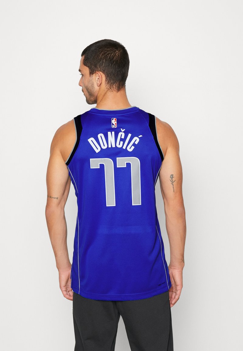 Niebieski strój koszykarski z czarnymi akcentami, na plecach z nadrukiem „DONČIĆ” w białym kolorze oraz numerem „77” w szarym, z siateczkową teksturą.