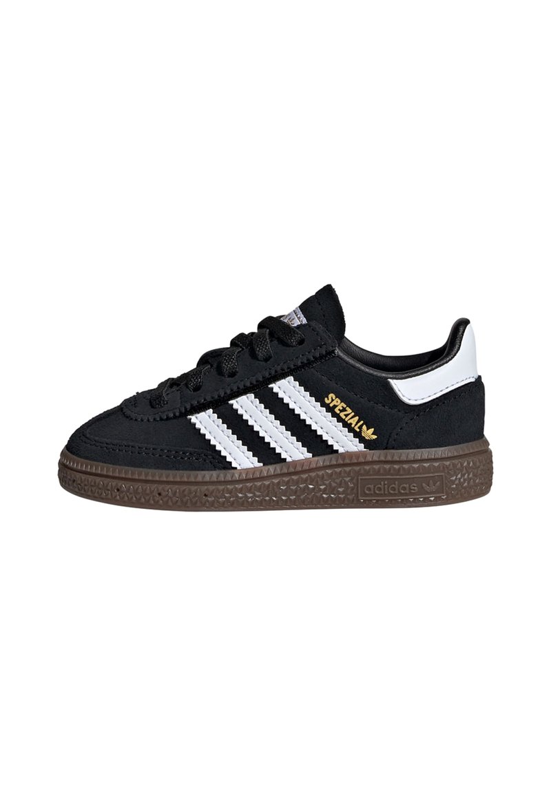 Sorte semskede sneakers med tre hvite striper, brun teksturert såle og gull "Spezial" akse. Har en polstret krage og svarte lisser.