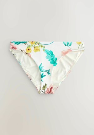 Blommig bikiniunderdel med vit bakgrund som har färgglada blommor och blad, vinklad för att visa midjan och tryckdetaljer.