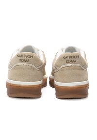 Beige Wildlederschuhe mit weißen Akzenten, ausgestattet mit einer flachen Gummisohle und dem geprägten Logo "GATTINONI ROMA" auf der Ferse.